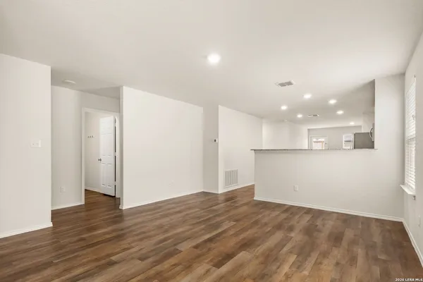 a view of an empty room with wooden floor