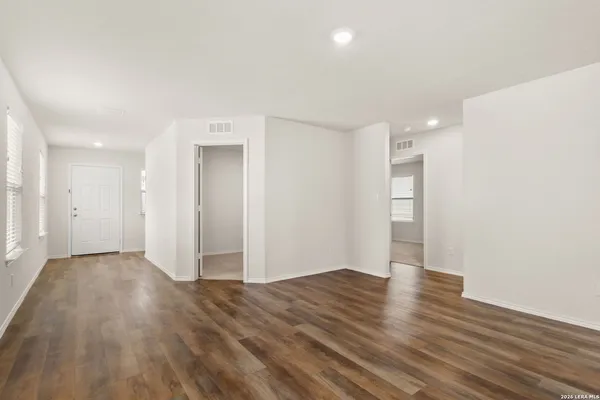 a view of an empty room with wooden floor