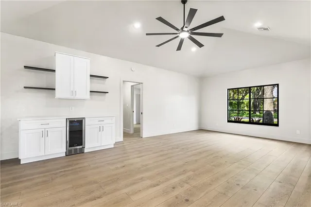 an empty room with windows and ceiling fan