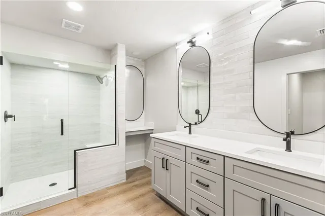 a bathroom with double vanity sink and a mirror