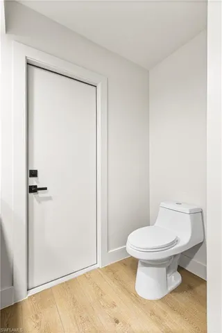 a white toilet sitting next to a shower