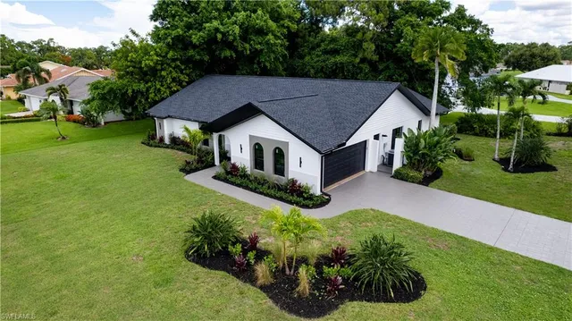a aerial view of a house with a yard table and chairs