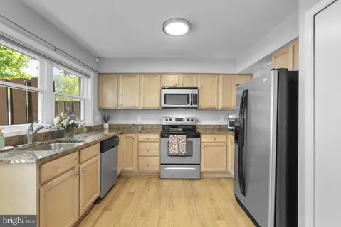 a kitchen with a sink a refrigerator a stove a microwave and cabinets
