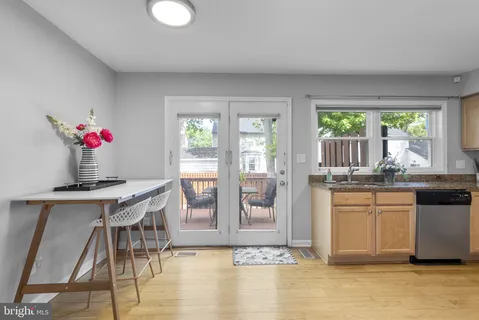 a dining hall with granite countertop a stove a sink dishwasher and a dining table with garden view