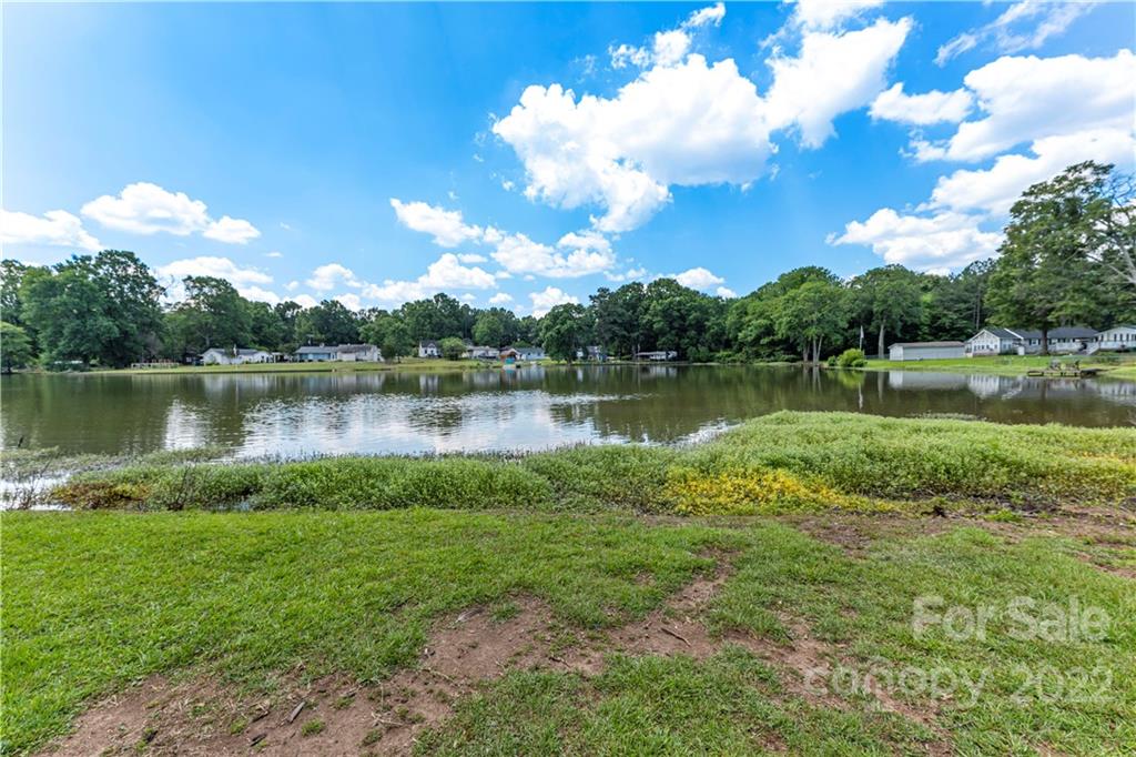 1248 West Shore Drive Lancaster, SC 29720 - Photo 2 of 27 a view of a lake with a yard and large trees