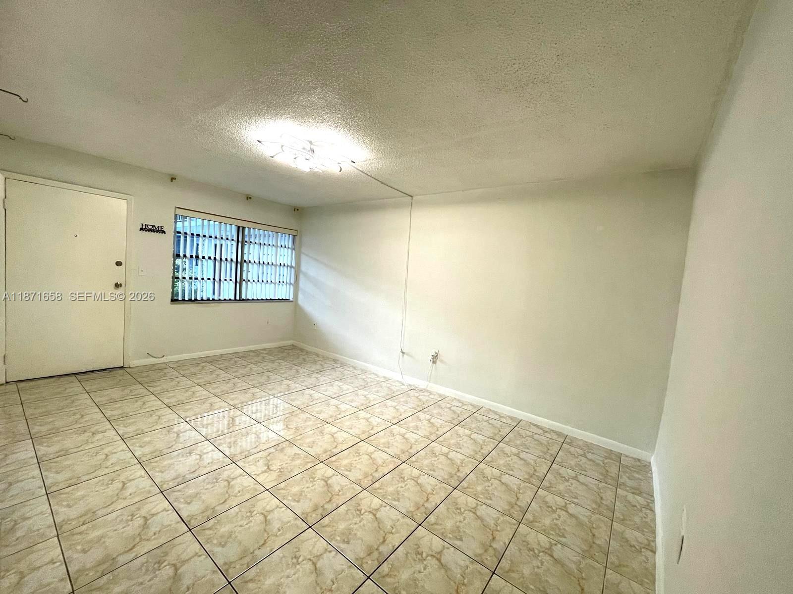 1335 West 68th Street, Unit 106 Hialeah, FL 33014 - Photo 5 of 20 an empty room with windows
