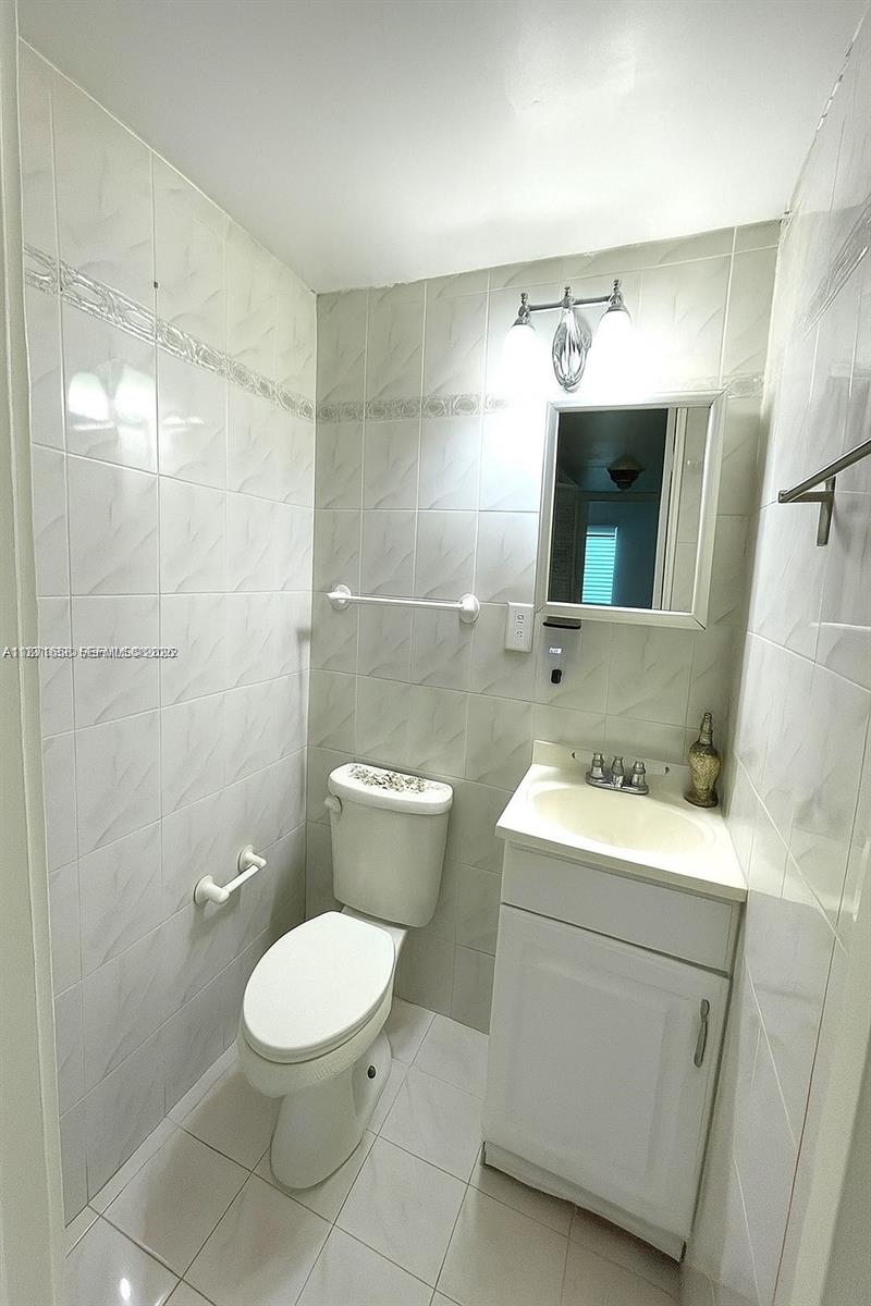 1335 West 68th Street, Unit 106 Hialeah, FL 33014 - Photo 6 of 20 a bathroom with a toilet sink and mirror
