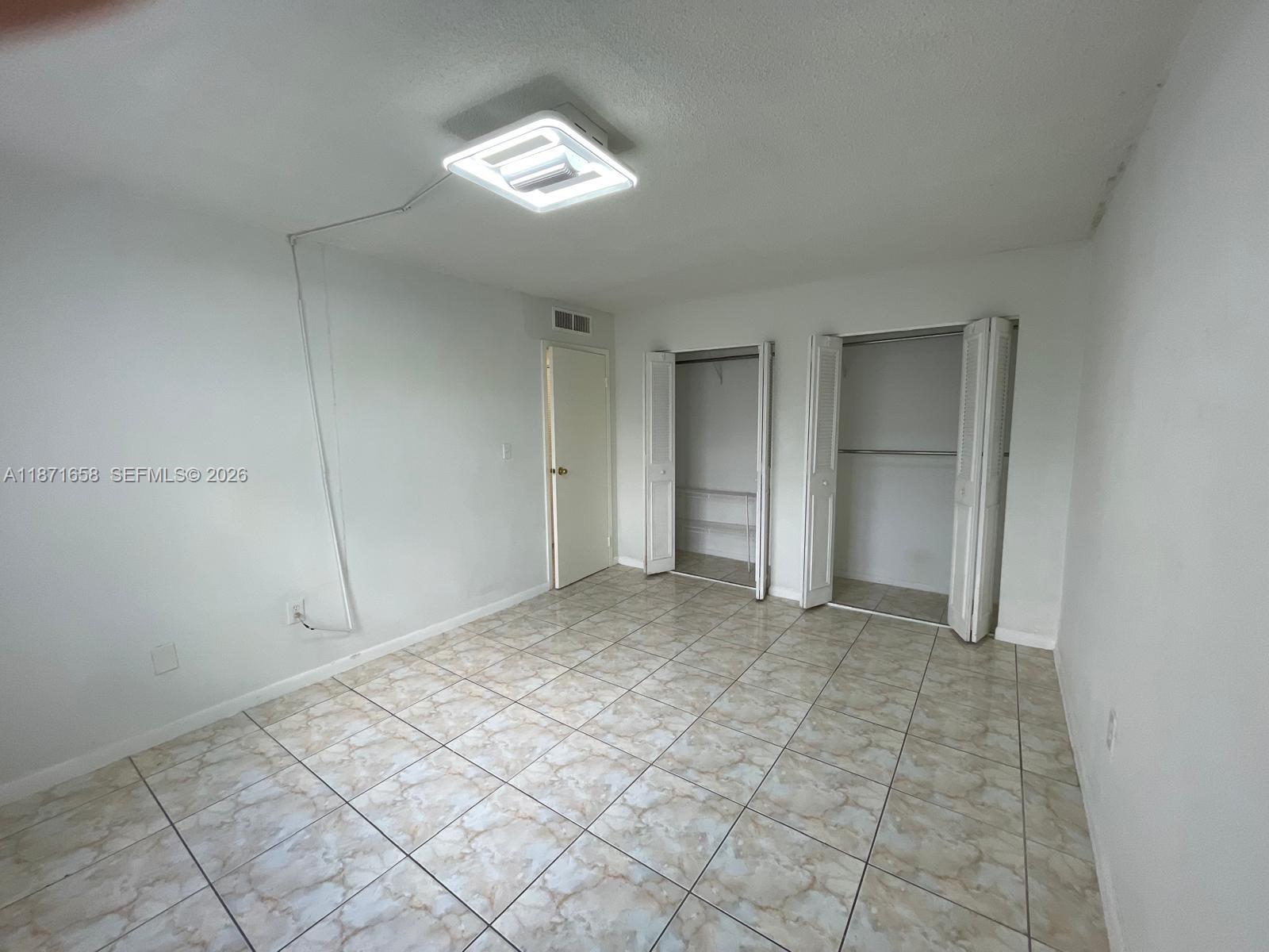 1335 West 68th Street, Unit 106 Hialeah, FL 33014 - Photo 10 of 20 a view of an empty room and window