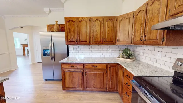 a kitchen with stainless steel appliances granite countertop a refrigerator a sink and a stove