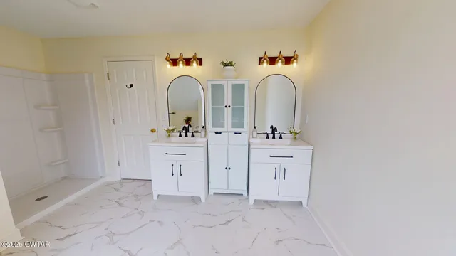 a bathroom with a double vanity sink mirror and shower