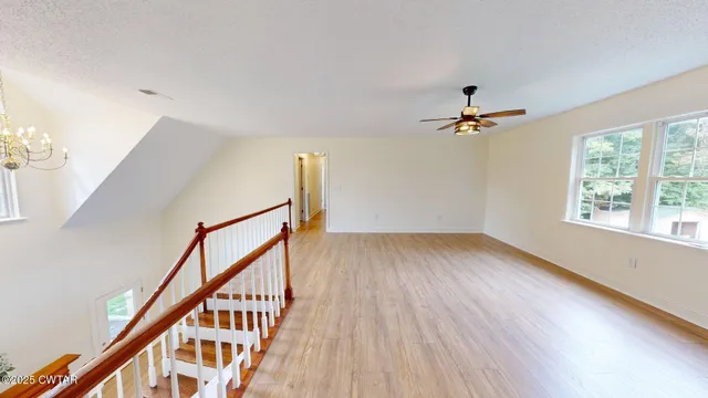a view of staircase and living room with wooden floor