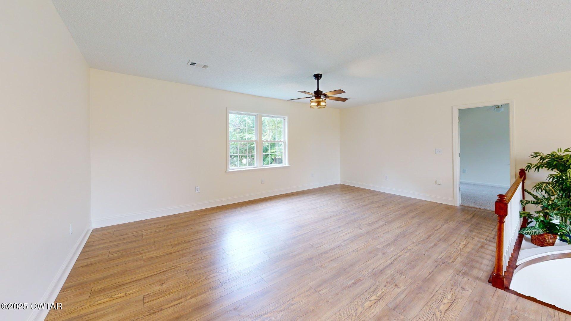 404 West Main Street Newbern, TN 38059 - Photo 28 of 35 an empty room with wooden floor and natural light