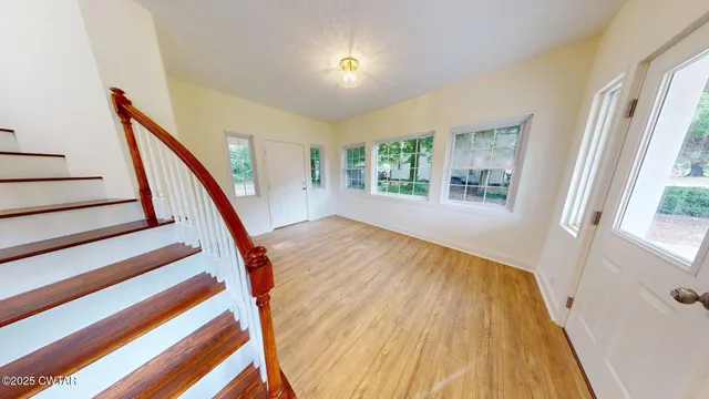 a view of an entryway with wooden floor and stairs