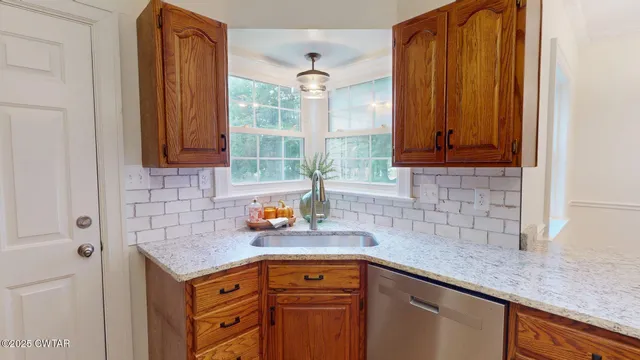 a kitchen with stainless steel appliances granite countertop a sink a refrigerator and cabinets
