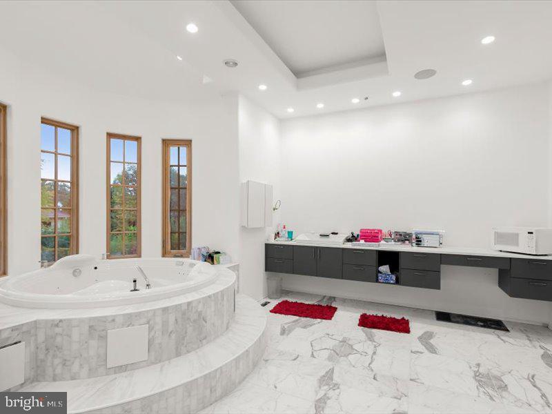 10130 Counselman Road Potomac, MD 20854 - Photo 104 of 135 a bathroom with a bathtub and a chandelier