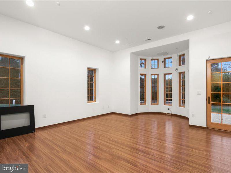 10130 Counselman Road Potomac, MD 20854 - Photo 25 of 135 a view of an empty room with wooden floor and a window