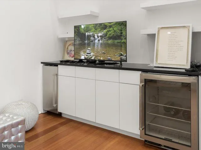 a view of a hallway with wooden floor and livingroom with furniture