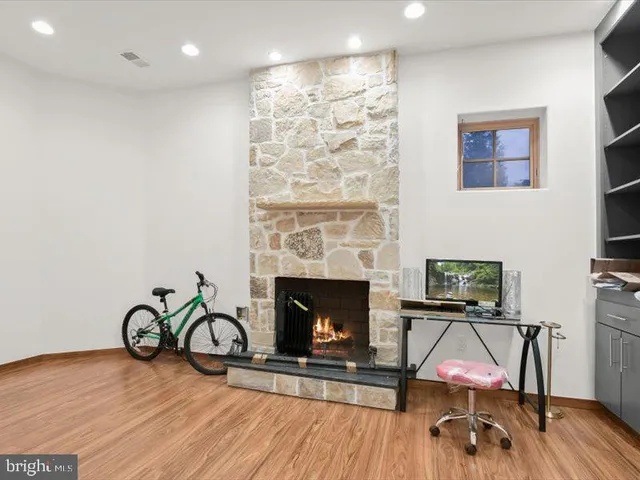 a view of an empty room with wooden floor and closet