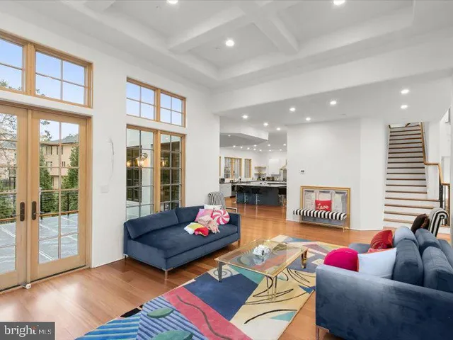 a view of a hallway with wooden floor and a living room