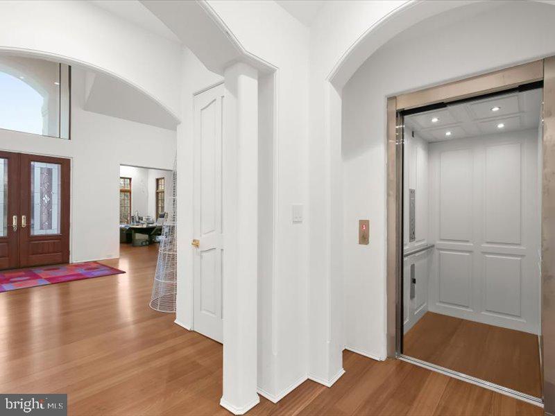 10130 Counselman Road Potomac, MD 20854 - Photo 77 of 135 a view of a hallway with wooden floor and livingroom with furniture