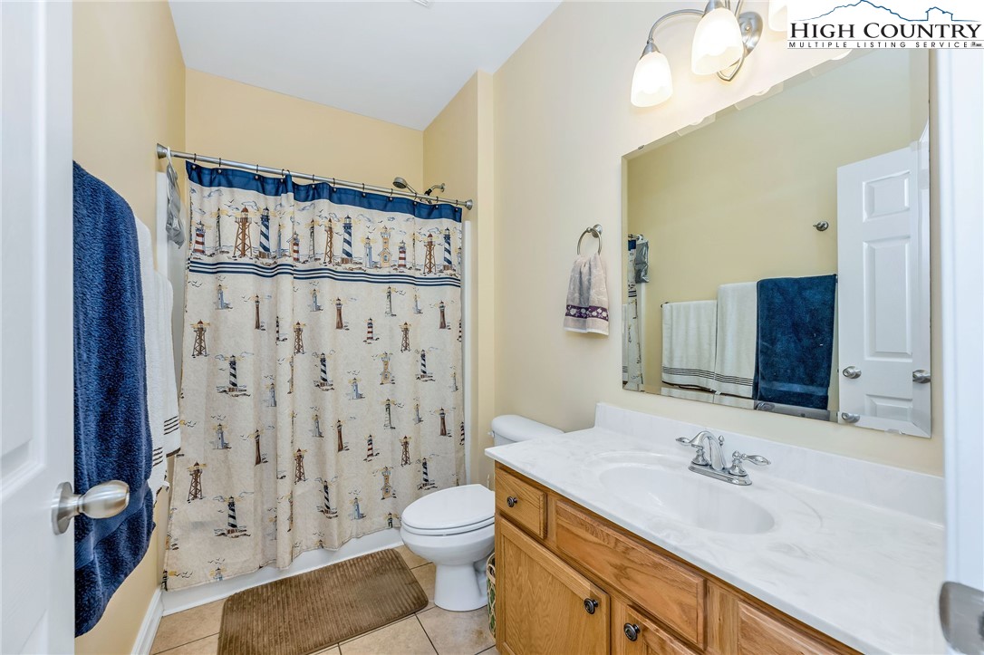 3186-3190 Silas Creek Road Lansing, NC 28643 - Photo 27 of 50 a bathroom with a granite countertop sink toilet a mirror and shower