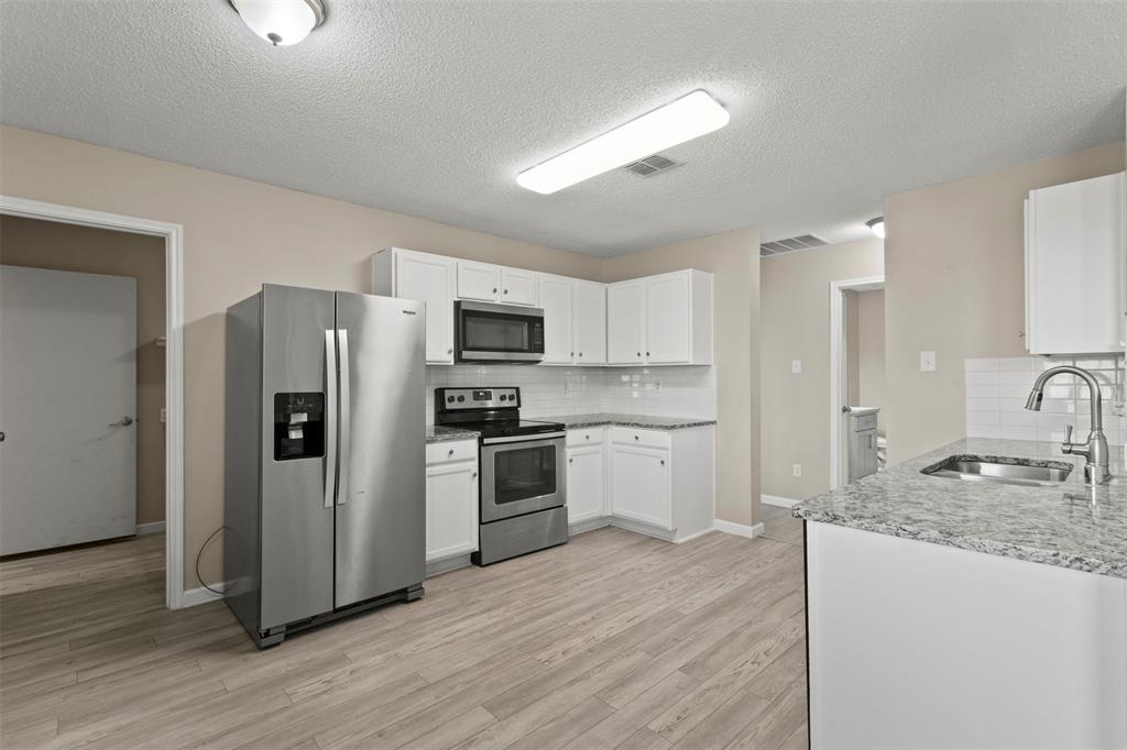 3004 Deer Ridge Drive Rockwall, TX 75032 - Photo 4 of 25 a kitchen with stainless steel appliances granite countertop a refrigerator sink and stove