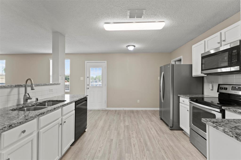 3004 Deer Ridge Drive Rockwall, TX 75032 - Photo 5 of 25 a kitchen with a sink stainless steel appliances and cabinets