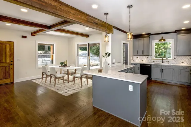 a dining hall with stainless steel appliances granite countertop a stove and chairs with wooden floor