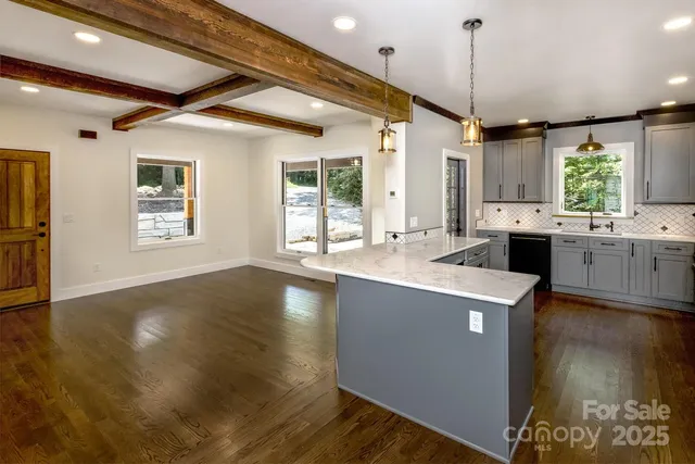 a kitchen with stainless steel appliances granite countertop a sink a stove and a wooden floors