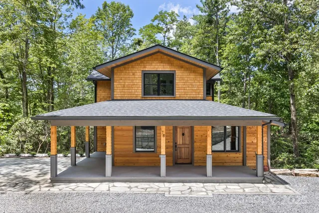 a view of a house with a yard and large tree