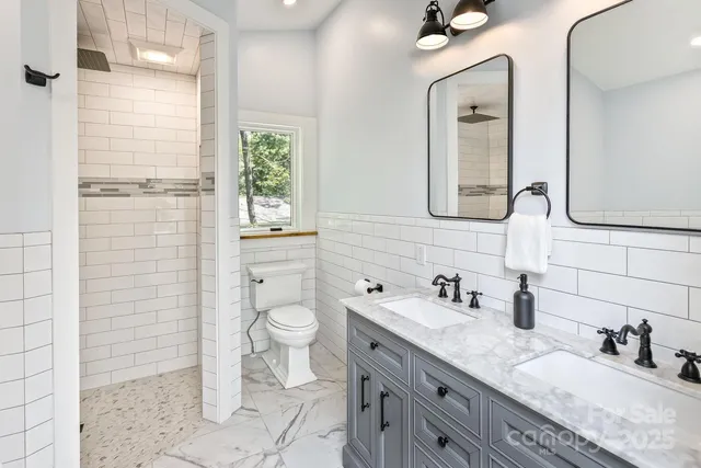 a bathroom with a granite countertop toilet a sink and a mirror