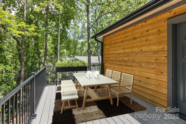 a view of a patio with table and chairs with wooden floor and fence