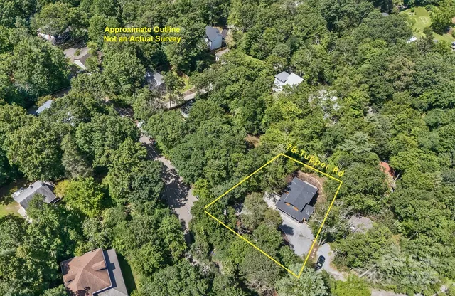 an aerial view of residential houses with outdoor space and trees