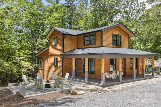a view of a house with a yard and large tree