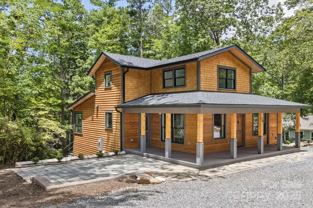 a view of a house with a yard and large tree