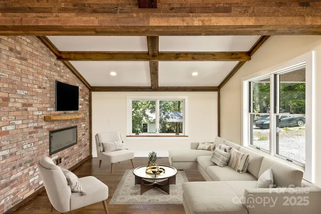 a living room with furniture a fireplace and a flat screen tv