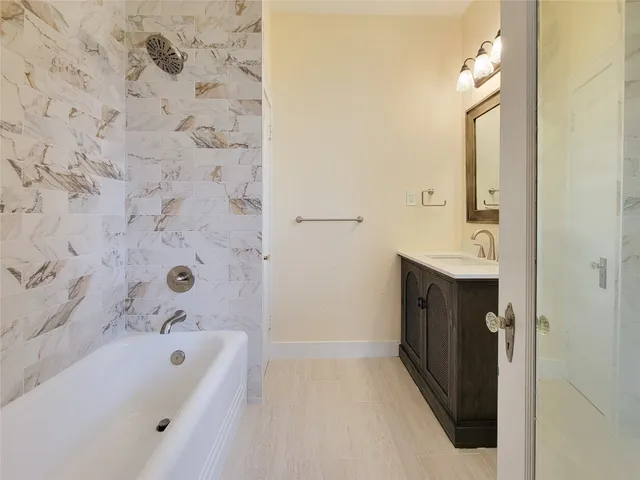 a bathroom with a tub sink and mirror