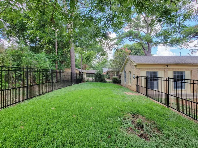 a view of a yard with a small yard and wooden fence