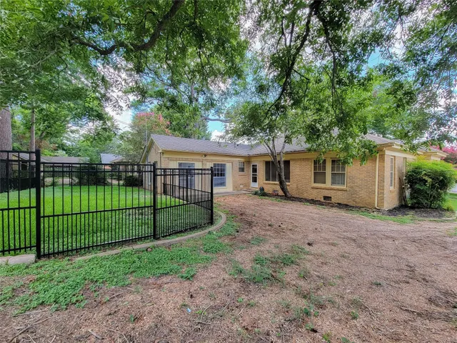 a view of a house with a backyard and a tree