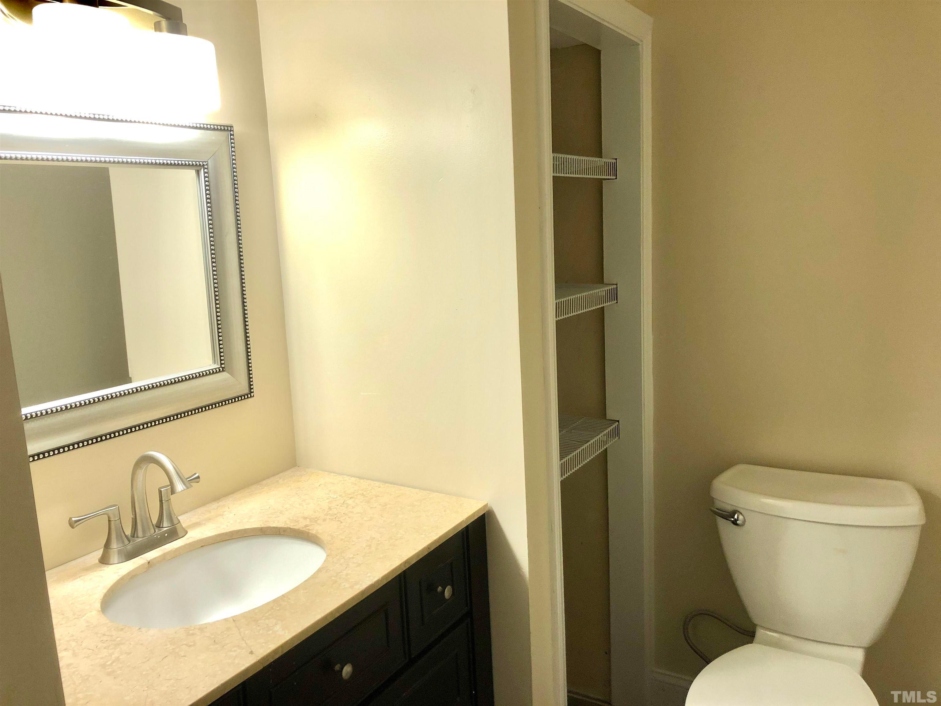 5629 Hamstead Crossing Raleigh, NC 27612 - Photo 14 of 28 a bathroom with a granite countertop toilet sink and mirror