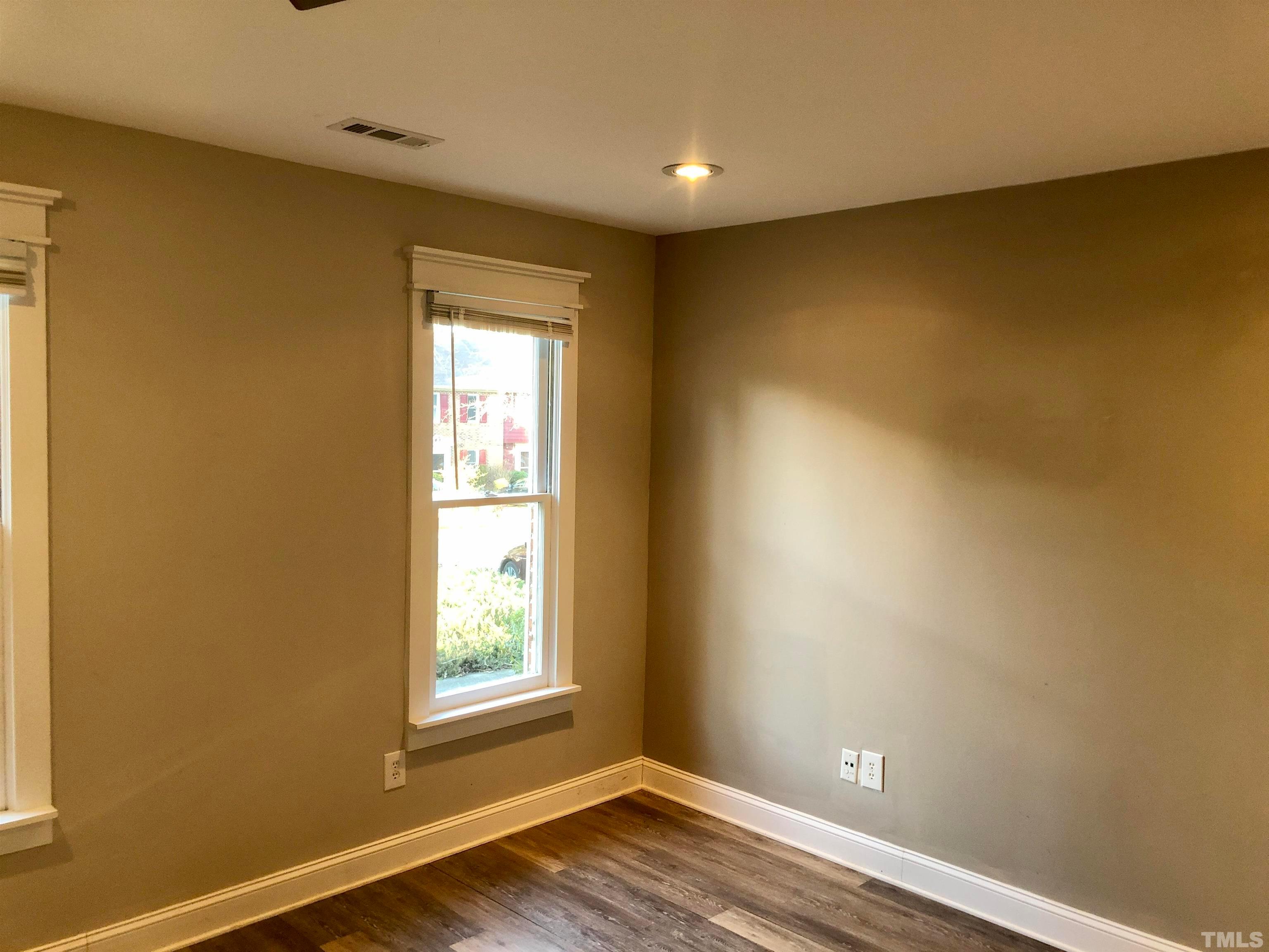 5629 Hamstead Crossing Raleigh, NC 27612 - Photo 6 of 28 a view of an empty room with wooden floor and a window