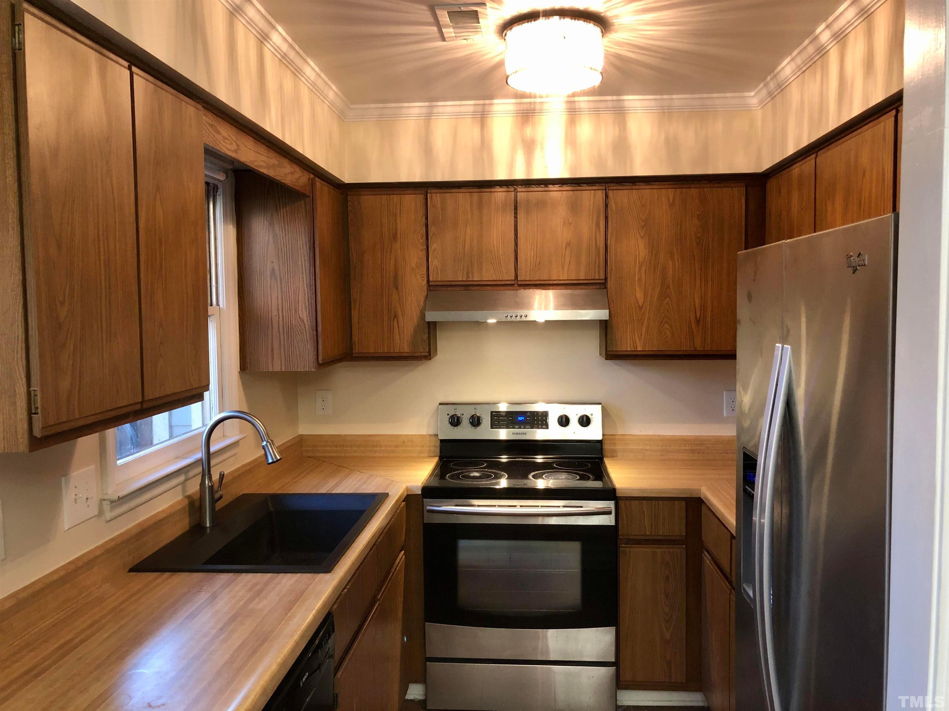 5629 Hamstead Crossing Raleigh, NC 27612 - Photo 9 of 28 a kitchen with a sink cabinets and stainless steel appliances