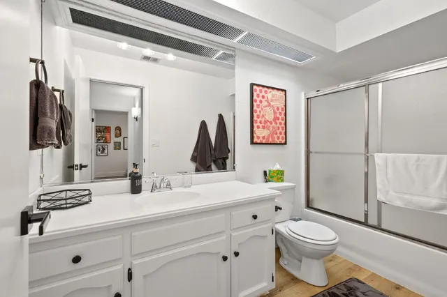 a bathroom with a sink a toilet and a mirror