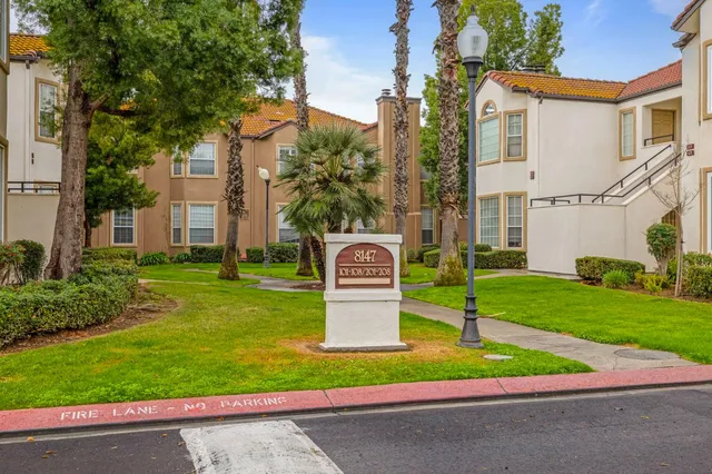 a front view of a house with a garden and plants