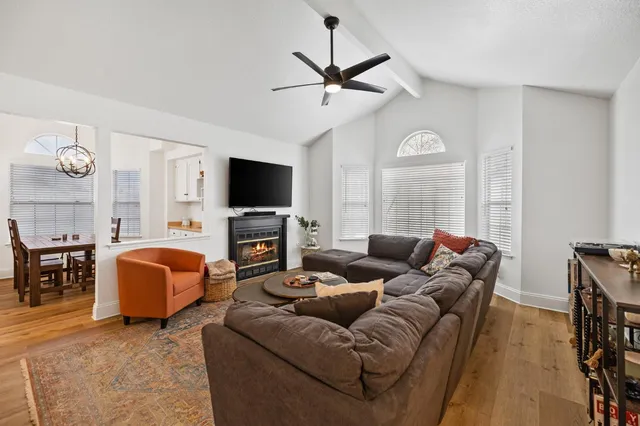 a living room with furniture a ceiling fan and a flat screen tv