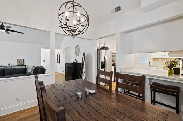 a view of a dining area with furniture a kitchen and chandelier