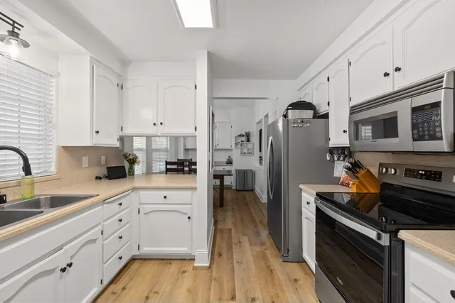 a kitchen with white cabinets and stainless steel appliances