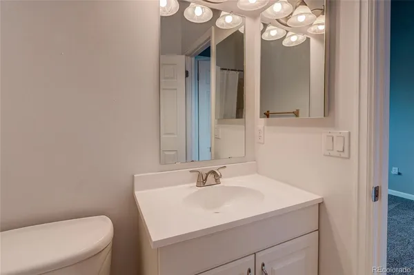 a bathroom with a sink vanity mirror and toilet