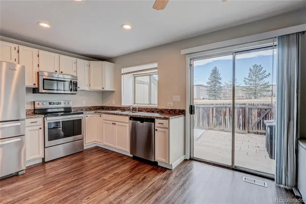 a kitchen with kitchen island granite countertop a stove a sink and a refrigerator