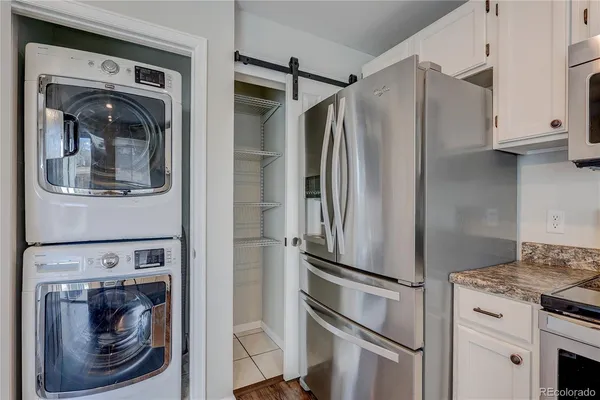 a metallic refrigerator freezer and a stove sitting inside of a kitchen